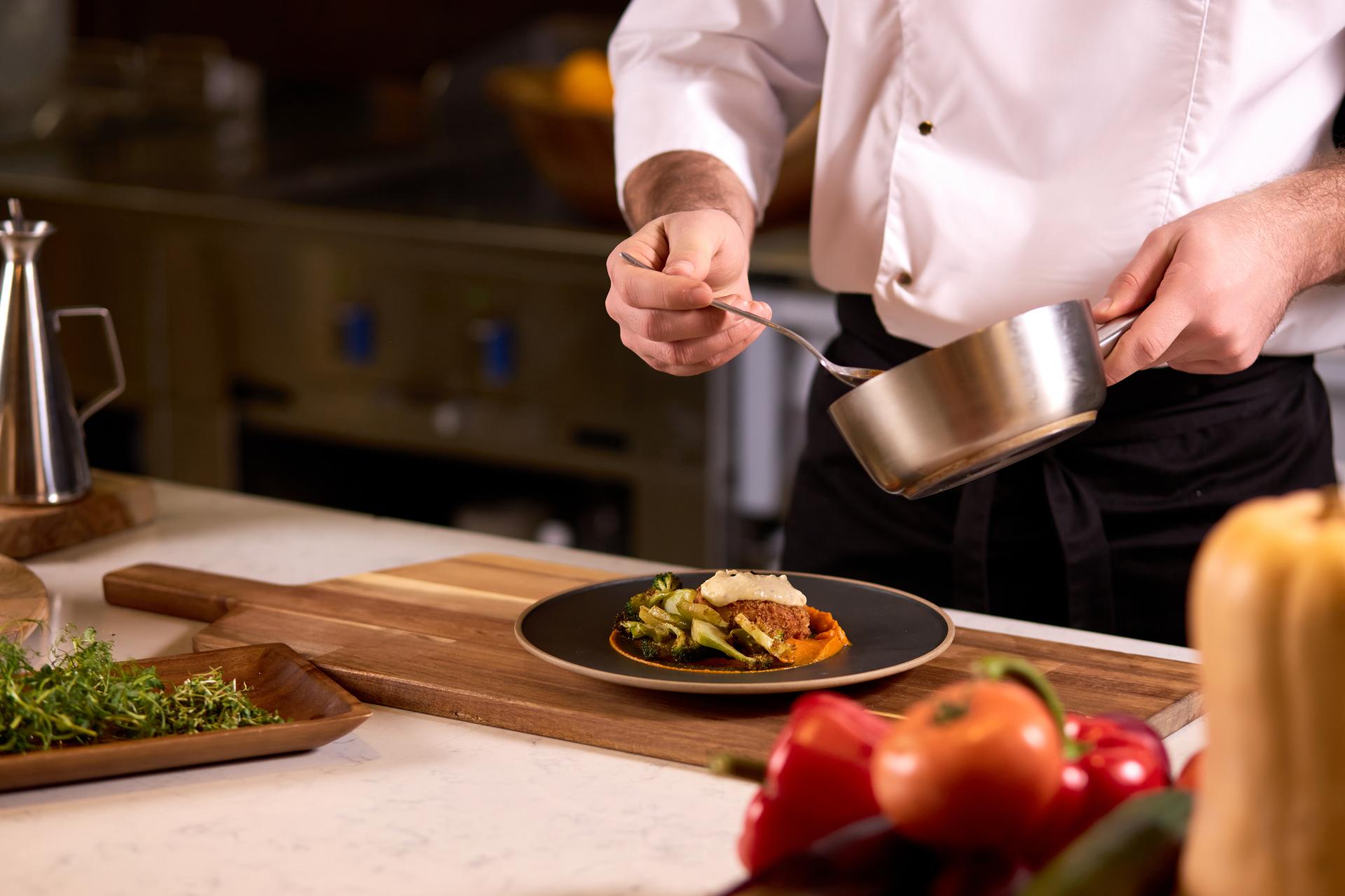 Cocinero emplatando en una cocina profesional